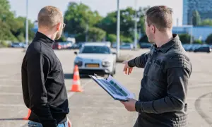Instruktor omawia trasę egzaminu na kartę motorowerową z kursantem, wskazując na schemat.
