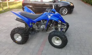 Niebieski Yamaha Raptor 350, quad z mocnym silnikiem, gotowy do jazdy. Ile ma koni? To pytanie dla fanów off-roadu!
