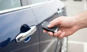 Dłoń trzyma kluczyk do samochodu, gotowa do użycia funkcji keyless go.