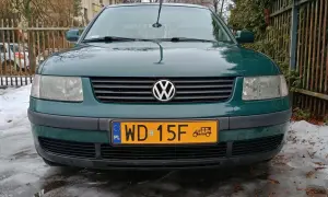 Zielony samochód zabytkowy, może 25 czy 30 lat, z charakterystycznym znaczkiem VW na grillu, stoi na oblodzonym podjeździe.