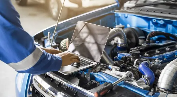 Mechanik sprawdza komputerem silnik, zastanawiając się, czy chip tuning jest bezpieczny.
