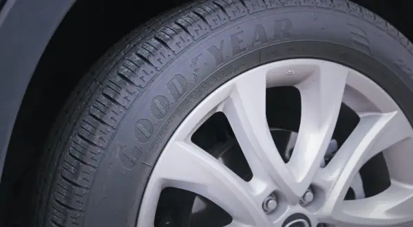 Koło samochodu z oponą Goodyear, gotowe do konserwacji. Dbałość o opony to klucz do bezpieczeństwa.