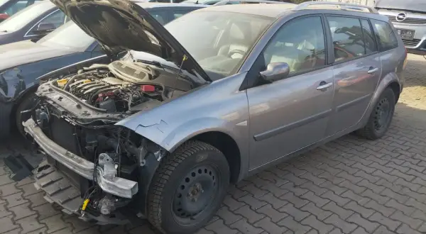 Szary kombi z otwartą maską, widoczny silnik i uszkodzony przód. Idealny, by dowiedzieć się, jak sprzedać auto na części.
