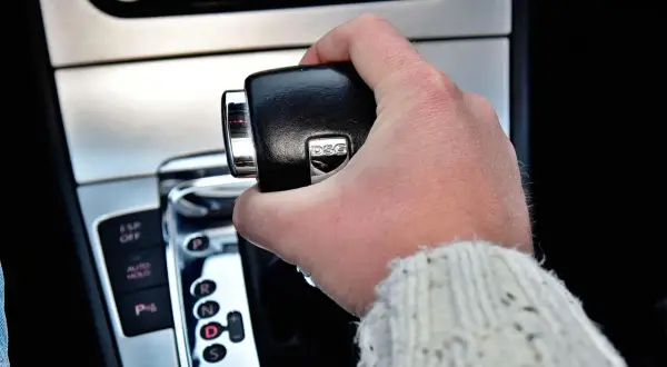 Dłoń trzymająca dźwignię zmiany biegów w samochodzie z automatycznymi skrzyniami biegów DSG.