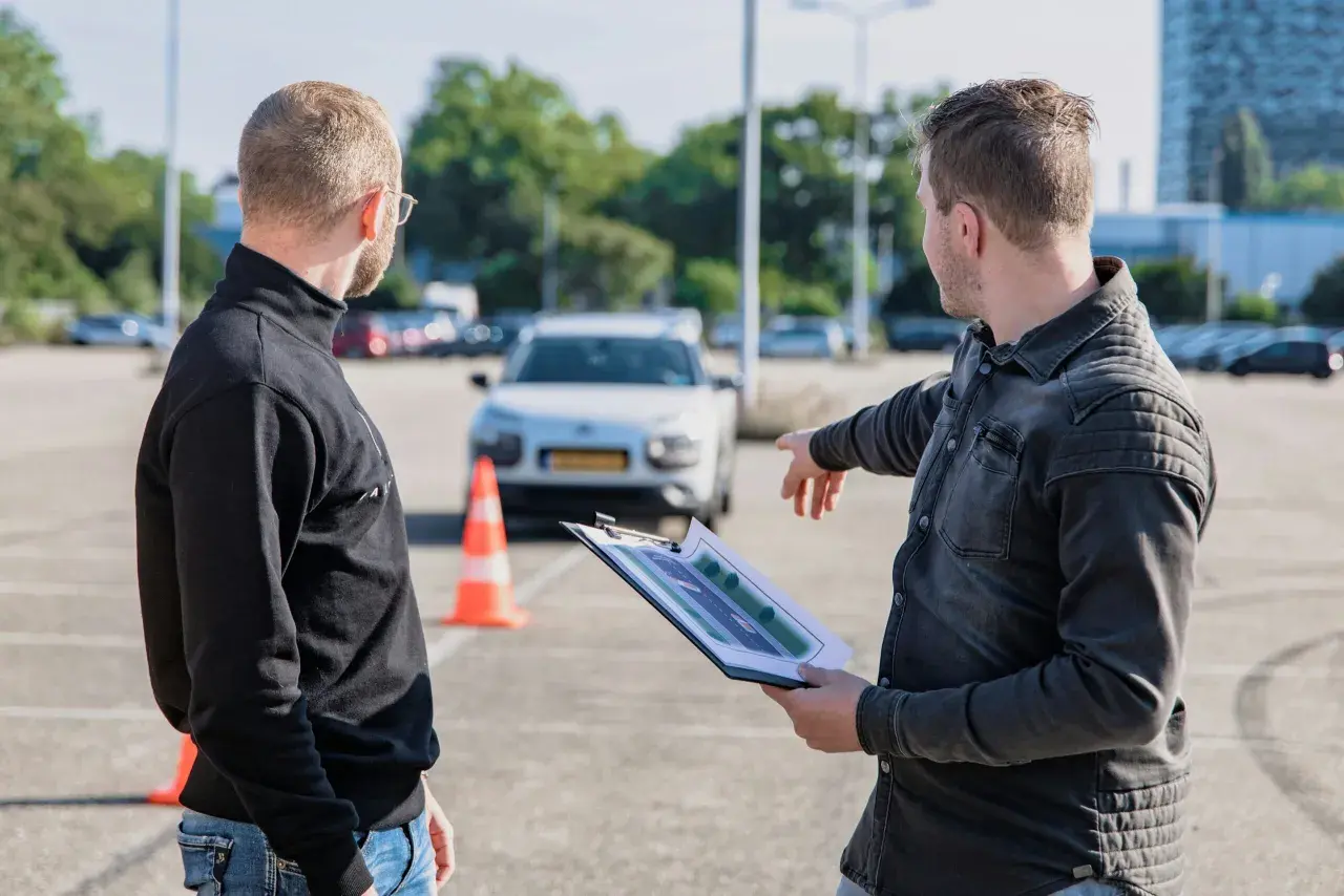 Instruktor omawia trasę egzaminu na kartę motorowerową z kursantem, wskazując na schemat.