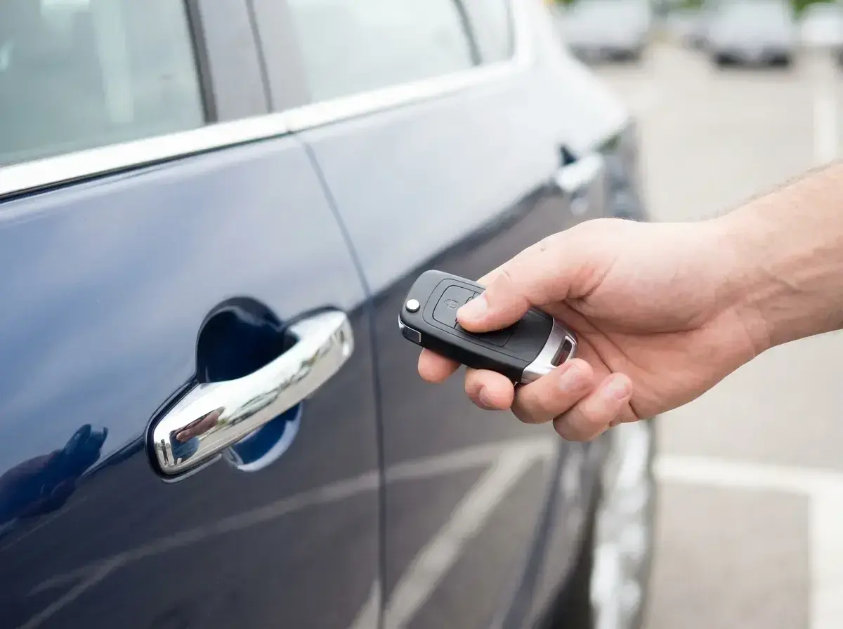 Dłoń trzyma kluczyk do samochodu, gotowa do użycia funkcji keyless go.
