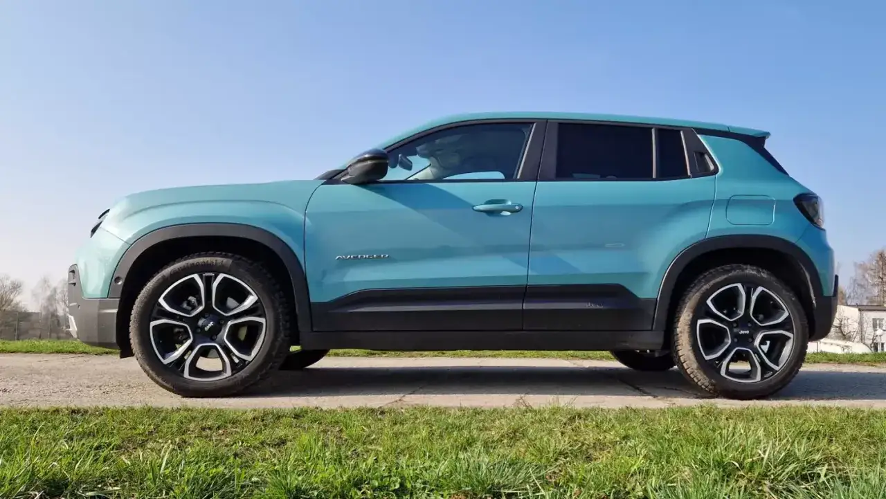 Turkusowy Jeep Avenger gotowy do jazdy samochodem po słonecznej drodze.
