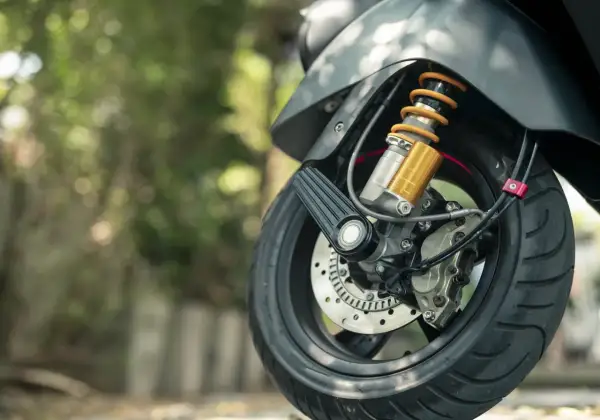 Szczegół przedniego koła motocykla z amortyzatorem i tarczą hamulcową. Idealny do dokumentowania umowa sprzedaży motocykla.
